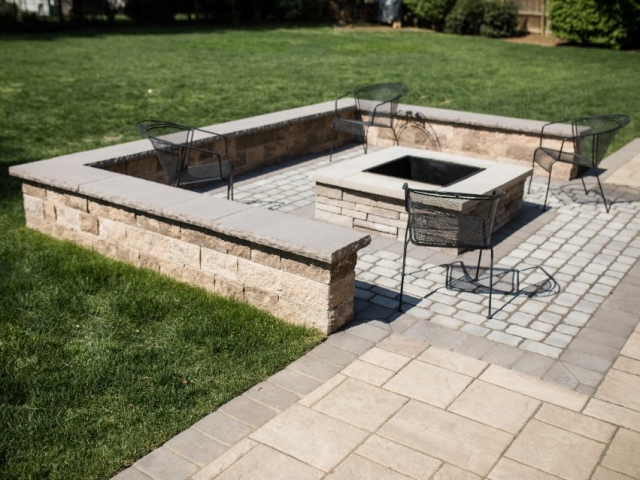 Check out this fire pit we installed during this stone patio installation project in camp hill PA. The weather was just too good for us! This image shows 4 metal chairs surrounding the fire pit.